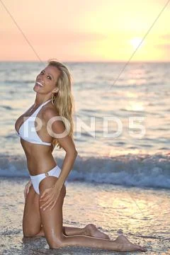 Woman in bikini on the beach at sunset Stock Photos