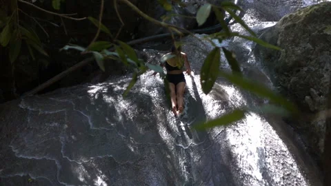 Woman In Bikini Slide On Waterfall Into  