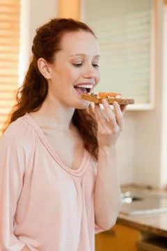 Woman biting into slice of bread Stock Photos