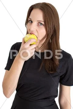 Woman biting a yellow apple Stock Photos
