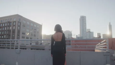 Woman in Black Dress Stands on Rooftop L... | Stock Video | Pond5