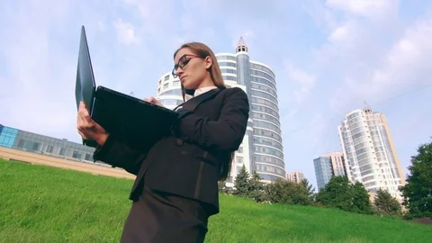 Woman in black suit check 5G connection via laptop on the street Stock Footage