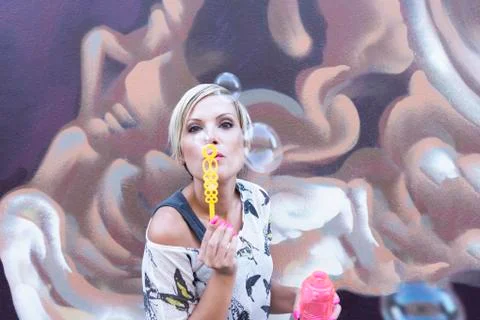 Woman is blowing bubbles Stock Photos