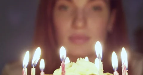 Woman blowing out candle on her birthday cake Stock Footage
