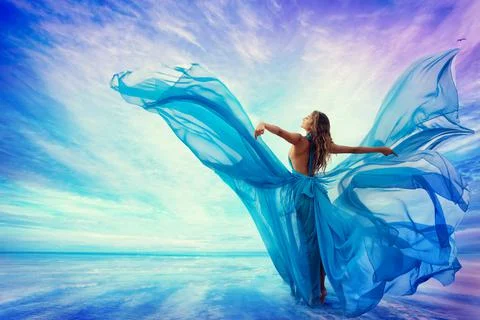 Woman in Blue Dress Flying on Wind looking at Sky and Sea. Fantasy Lady Art Stock Photos
