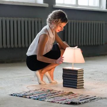 Woman with books and bright light bulb Stock Photos