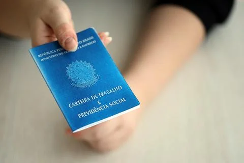 Woman boss gives a brazilian work card and social security blue book to us in Stock Photos