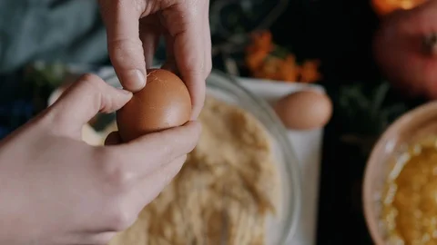 Woman breaking an egg open into a mixture Stock Footage 114908058