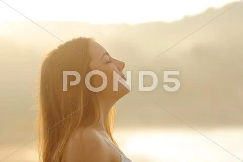 Woman breathing deep fresh air in the morning sunrise Stock Photos