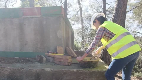 Woman bricklayer works in construction using and preparing cement Видео 270455753