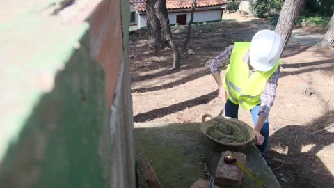 Woman bricklayer works in construction using and preparing cement Stockbeeldmateriaal 270455962