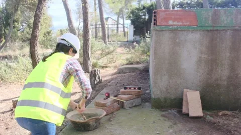 Woman bricklayer works in construction using and preparing cement Vídeos de archivo 270456205