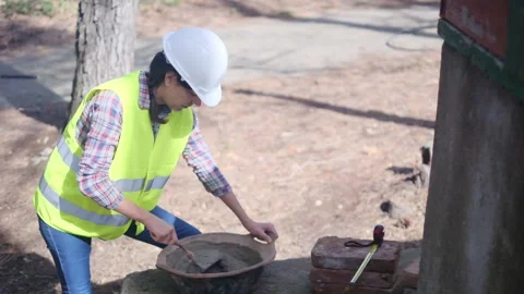 Woman bricklayer works in construction using and preparing cement Stockbeeldmateriaal 270456243