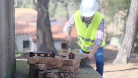 Woman bricklayer works in construction using and preparing cement Stockbeeldmateriaal 270456250