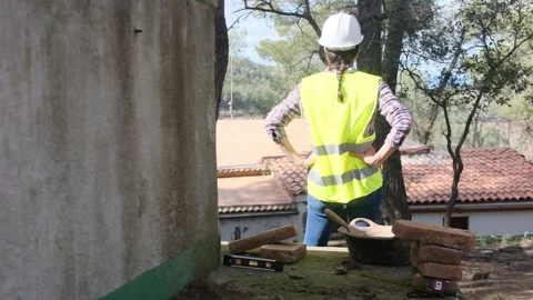 Woman bricklayer works in construction using and preparing cement Видео 270456615