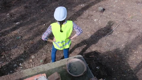 Woman bricklayer works in construction using and preparing cement Stockbeeldmateriaal 270456637