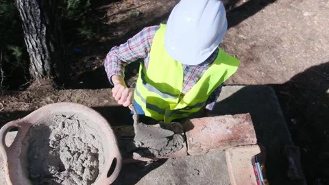 Woman bricklayer works in construction using and preparing cement Видео 270456928