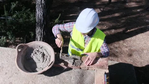 Woman bricklayer works in construction using and preparing cement Видео 270457012