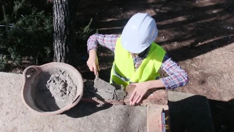 Woman bricklayer works in construction using and preparing cement Vídeos de archivo 270457048