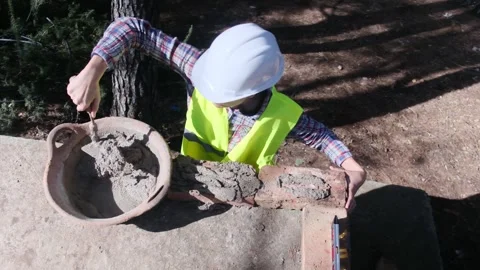 Woman bricklayer works in construction using and preparing cement Vídeos de archivo 270457083