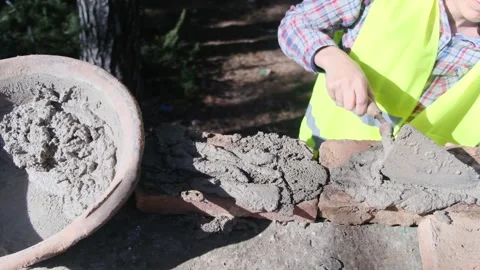 Woman bricklayer works in construction using and preparing cement Vídeos de archivo 270457181
