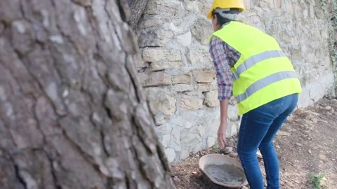 Woman bricklayer works in construction using and preparing cement Видео 270457380