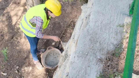 Woman bricklayer works in construction using and preparing cement Vídeos de archivo 270457543