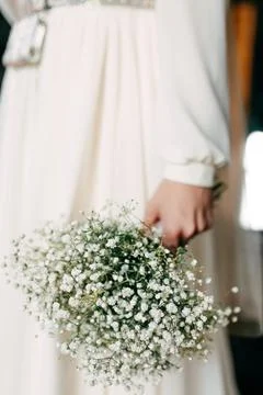 Woman bride in wedding dress holding white bouquet in hand Stock Photos
