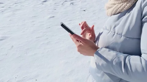 Woman browsing internet using smartphone outdoor in winter. Girl holding phone Stock Footage 244311857