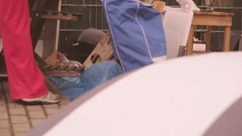 Woman browsing old items bulky waste collection point, Second life old item.. Stock Footage 335084911