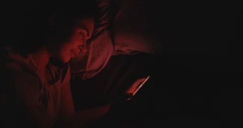 Woman Is Browsing Secrets. Red Light From Phone Screen. High Angle Stock Footage 125449064