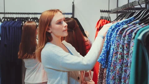 Woman browsing through clothes in store Stock Footage 278045568