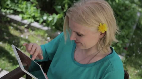 Woman browsing through something funny on tablet outside in summer Stock Footage 63321904
