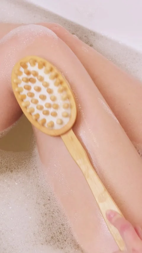 Woman brushing thigh while relaxing in bubble bath Stock Footage 328632937