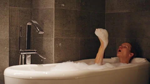 Woman in Bubble Bath Throwing Foam Upward with Slow Motion Effect and Close Angl Stock Footage 323634185