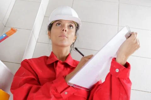 Woman builder taking notes at construction site Stock Photos