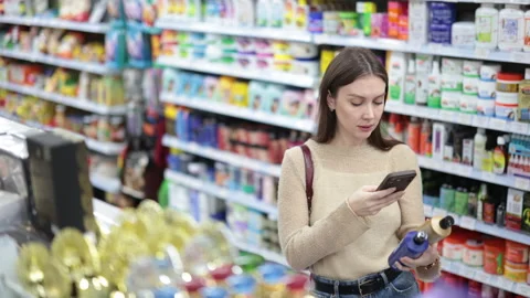 Woman buyer scanning qr code for shampoo or shower gel in household chemicals 動画素材 341783430
