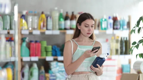 Woman buyer scans qr code on tile cleaner spray label Stock Footage 309522700