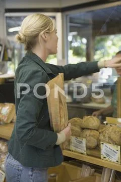 Woman buying bread at counter Stock Photos