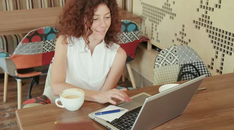 Woman in a cafe , drinking coffee and working on the laptop Stock Footage