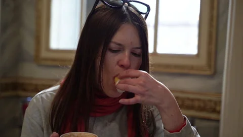 A woman in a cafe eats cake and drinks coffee. Stock Footage 256045984