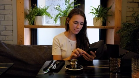 Woman in cafe learning language using an app Stock Footage 92118714