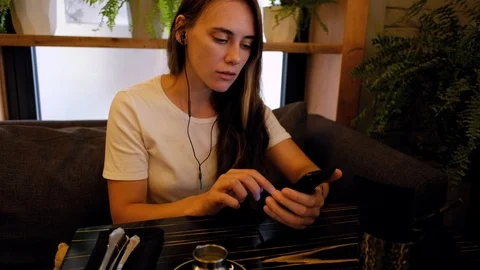 Woman in cafe learning language using an app Stock Footage 92124266