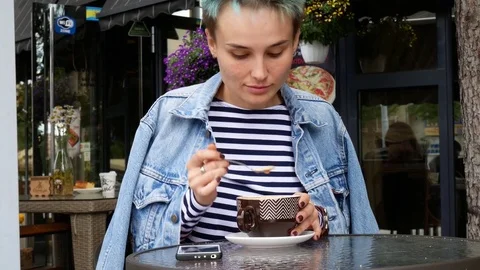 The woman in the cafe is waiting for someone. Waiting, sad young woman. Stock Footage