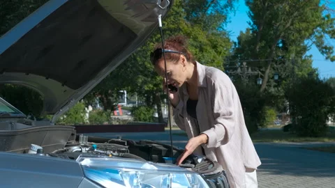 Woman calling for help with broken down car Stock Footage 344742811