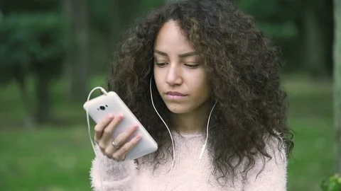 Woman calling someone using cell phone with earphone: teenager with smartphone Stock Footage 75552815