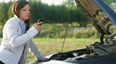 A woman calls for assistance after her car broke down HD Stock Footage