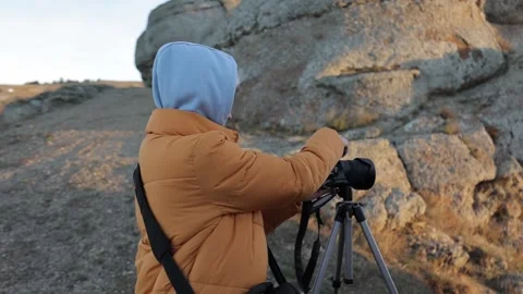 Woman with camera takes a landscape from the top of a mountain on sunny day 動画素材 170051553