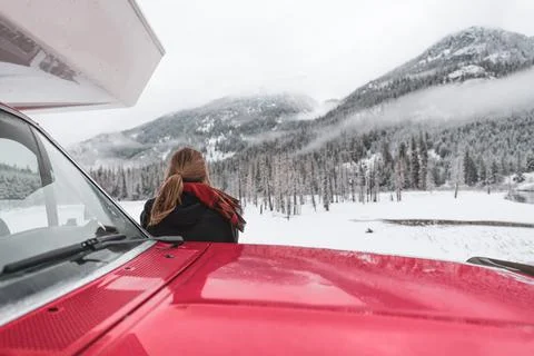 Woman by camper van in snow, Lillooet Lake, British Columbia, Canada Stock Photos
