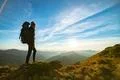 The woman with a camping backpack standing on the rock with a picturesque sun Photo